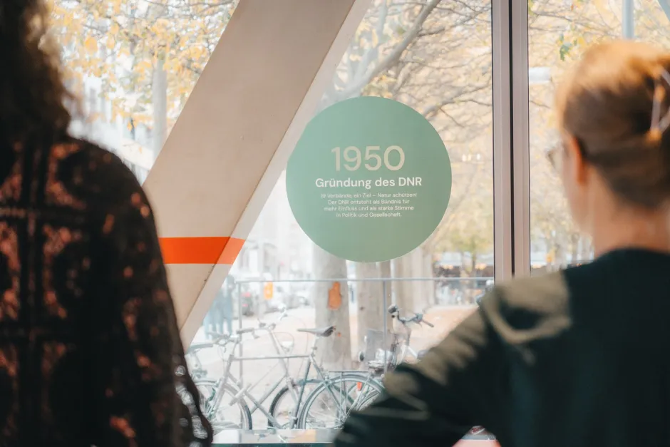 Blick auf die Ausstellung 75 Jahre DNR, Teil der Chronik, runder Sticker mit dem Jahr 1950 und dem Verweis auf die Gründung des DNR